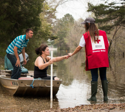 Wednesday March 16, 2016. McClain, Mississippi. Suzy Cooley and Aaron Cooley brave the flood waters on a fishing boat in McClain, MS. Red Cross volunteer, Sarah Basel, notifies them of a nearby Red Cross Point of Contact.