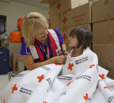 Volunteer Melody Belloff, a nurse, wraps up Kairi to keep her warm at a Red Cross shelter in Wickenburg, Arizona,