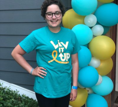 Olivia Stoy smiling next to balloons.