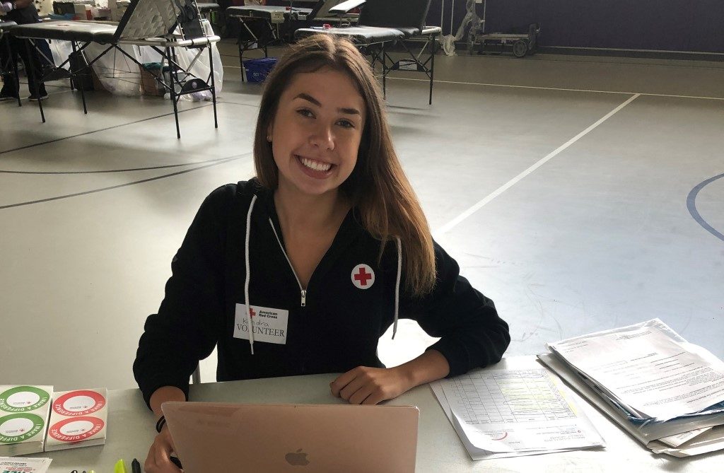 Kendra sitting at the sign in table during a blood drive. 